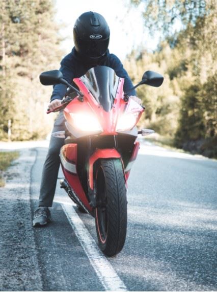 motorcyclist wearing a helmet parked on the side of the road